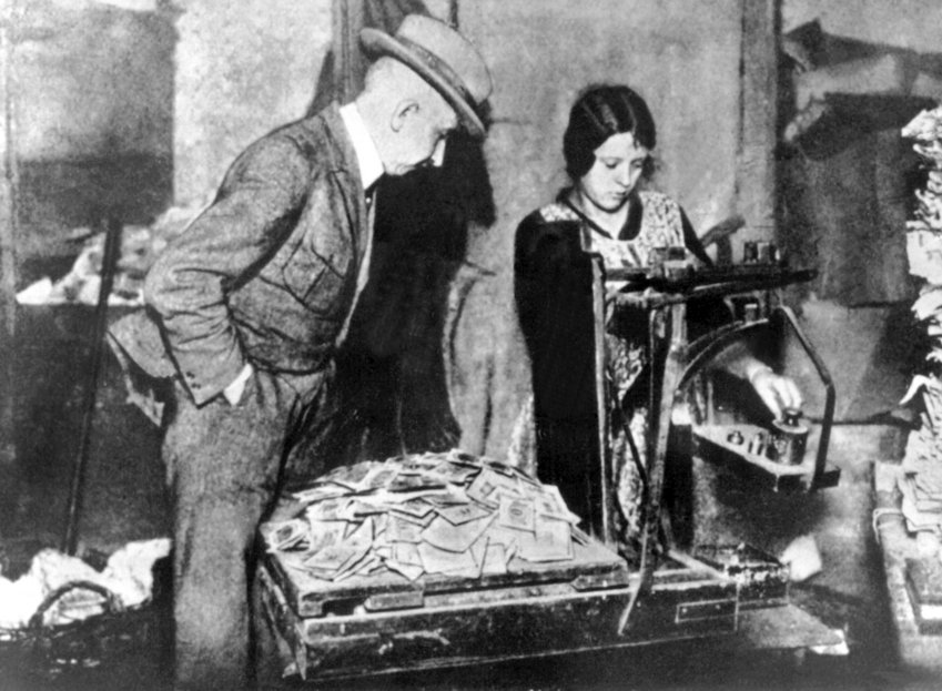 Homme et femme usine pèsent piles de billets mark allemands hyperinflation allemagne 1923